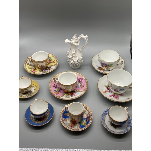144 - A Collection of Meissen pottery miniature cups and saucer & Meissen white glaze floral design ewer j... 