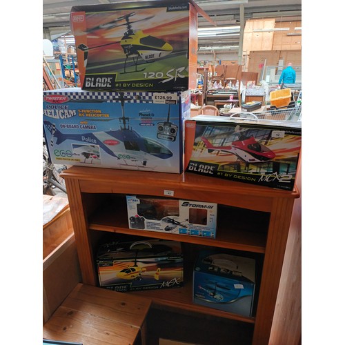 42 - Various boxed helicopter models along with a box full of controllers