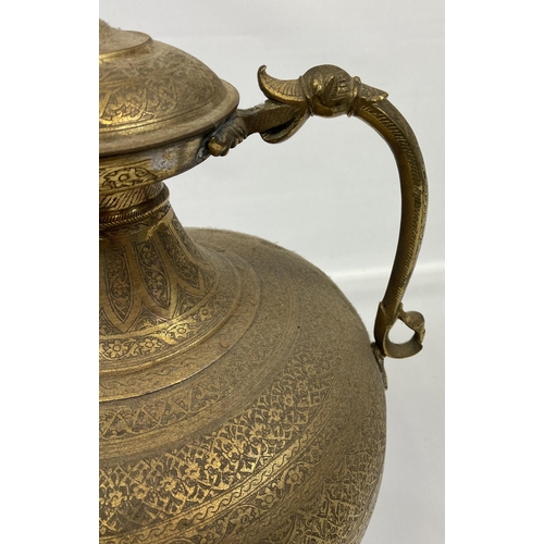 122 - A Large antique Indian gilt brass engraved tea pot. Designed with a dragon style head spout and hand... 
