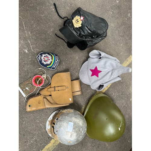 20 - A Selection of military items to include helmets, hats and holster.