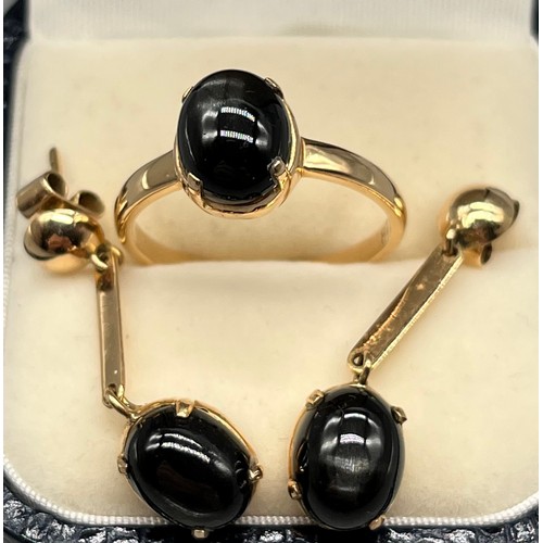 6 - A Yellow gold ring and matching earrings fitted with silver sheen black obsidian stones. Stamped 18.... 
