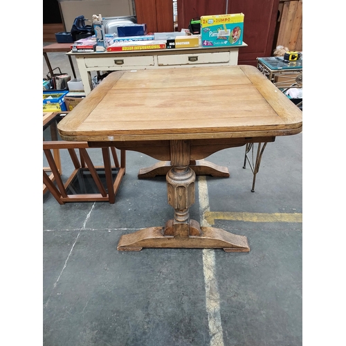 45 - An Art Deco light oak wood grain dining table. Comes with two leaves and heavy carved pedestal legs.... 