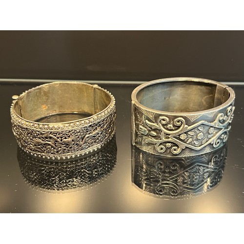 10 - A Chinese Silver marked ornate bangle, together with a Birmingham silver bangle. [88.25grams]