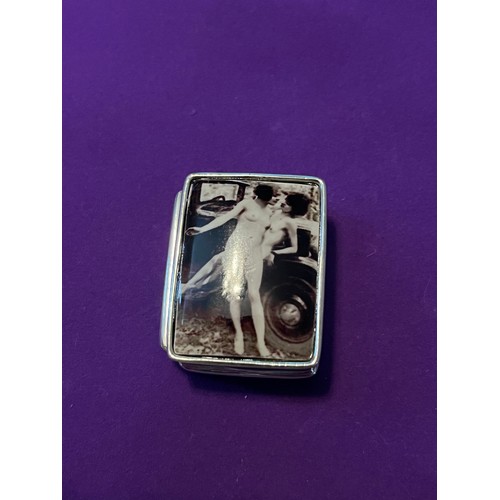 35j - A Silver pill box with enamel lid depicting two naked female figures
