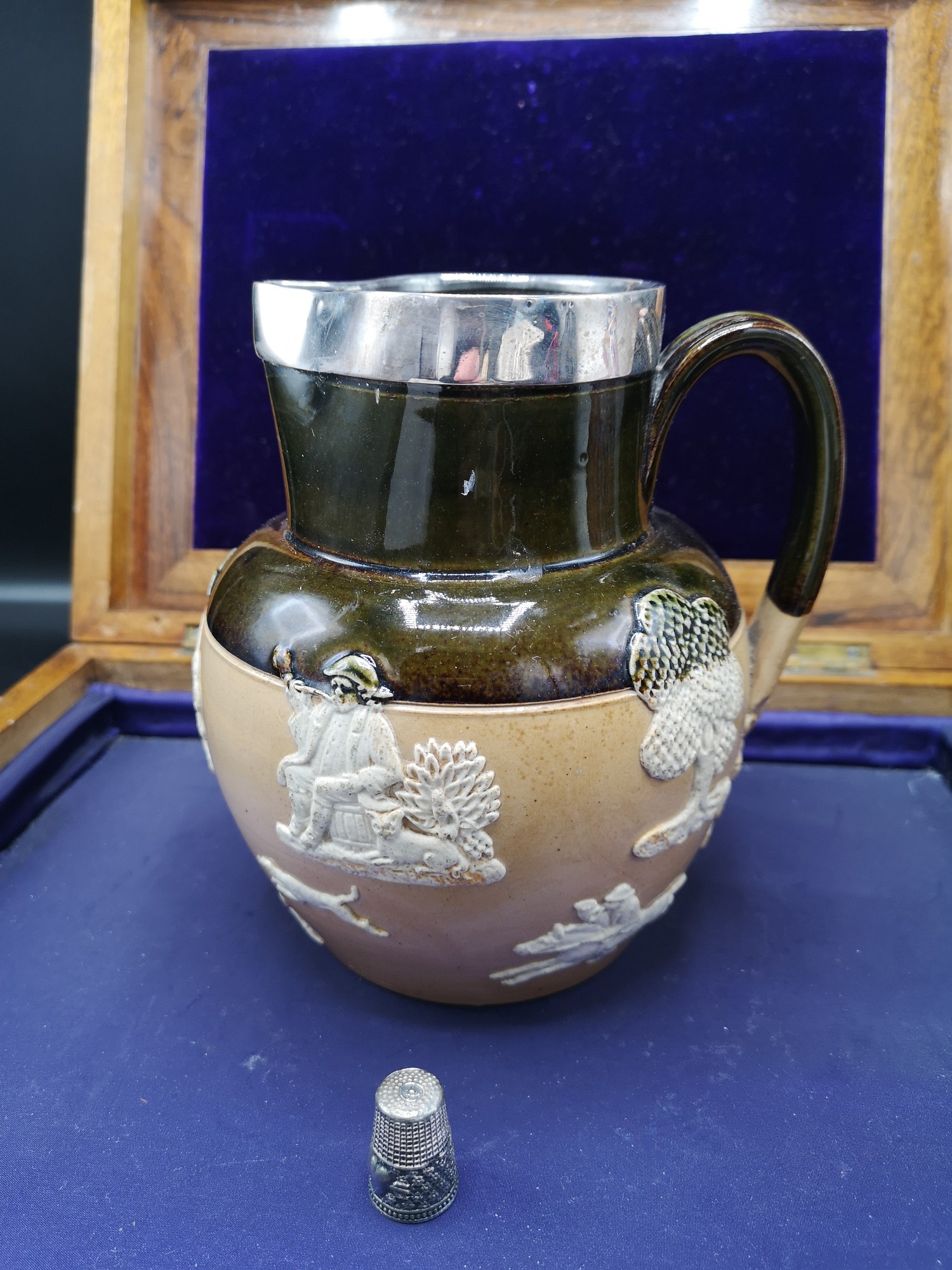 Early Royal doulton lambeth ware jug with silver Hall marked metal rim.