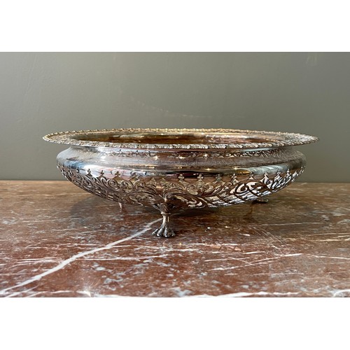 A shaped circular pierced silver fruit-basket. On three claw feet, the sides with trelliswork and foliage and with gadrooned border. With hallmarks. By James Dixon & Son, Sheffield, 1908.