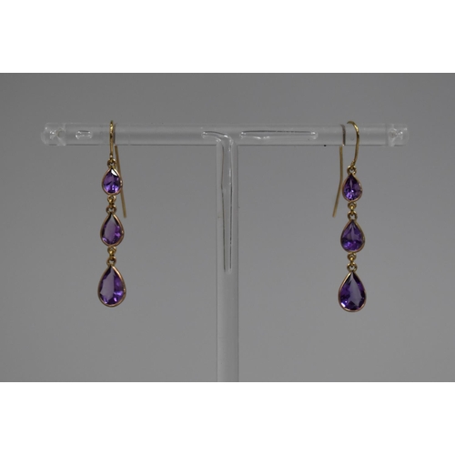 41 - A Pair of Amethyst and Gold Coloured Metal Drop Earrings, Each with Three Graduated Teardrop Shaped ... 