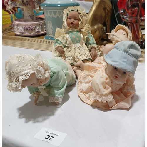 37 - Four small porcelain dolls.