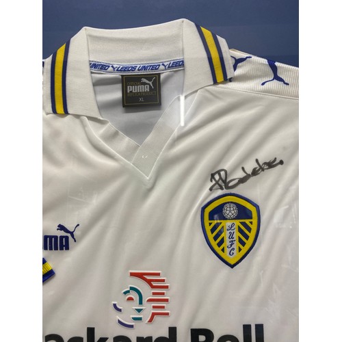 938 - A framed Leeds United football shirt with signatures to include Lucas Radebe and others.