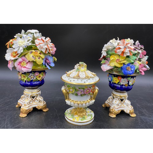 59 - Three pieces of Bloor Derby porcelain to include a pair of floral urns 18cms together with a lidded ... 