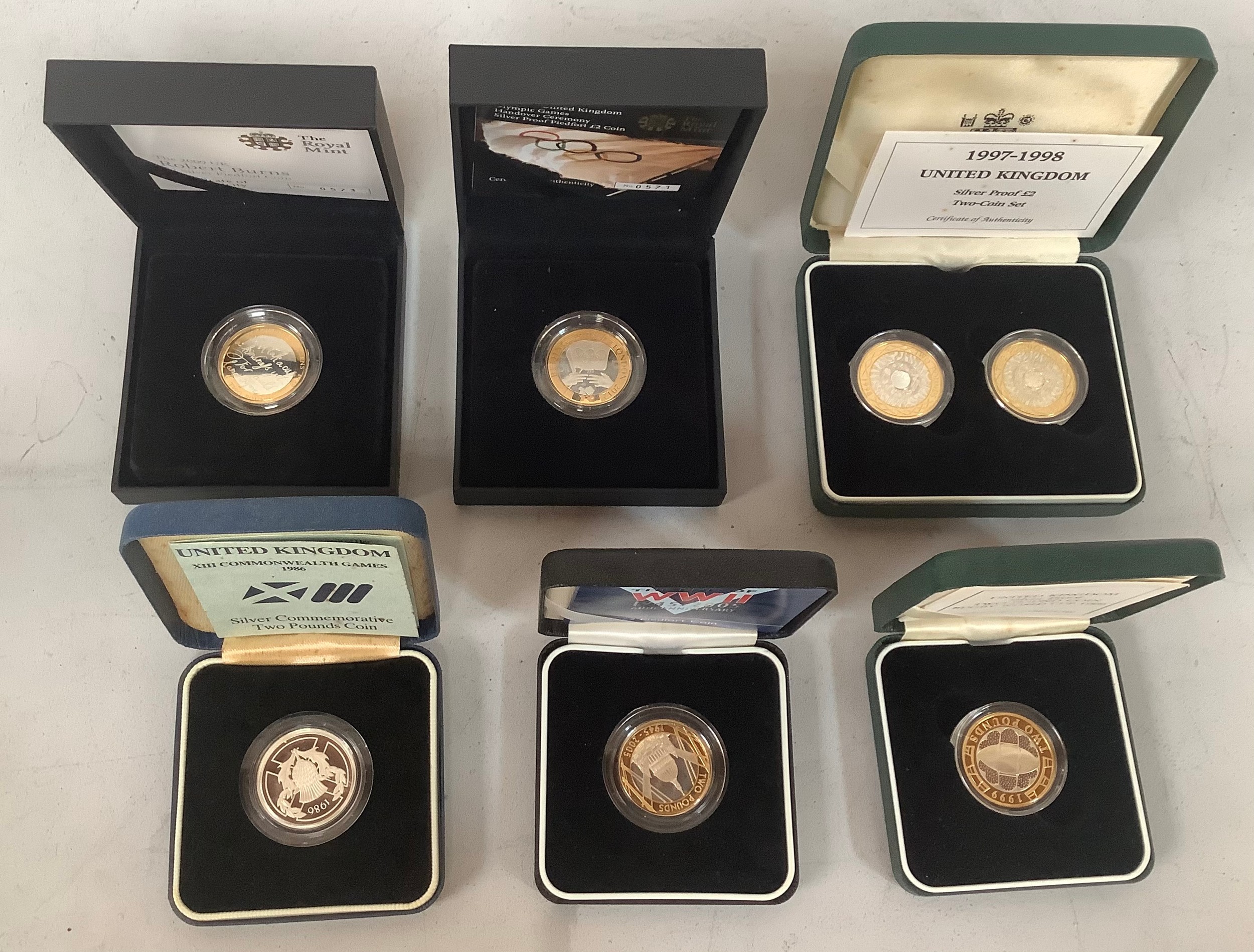A collection of seven boxed commemorative £2 coins, comprising some ...