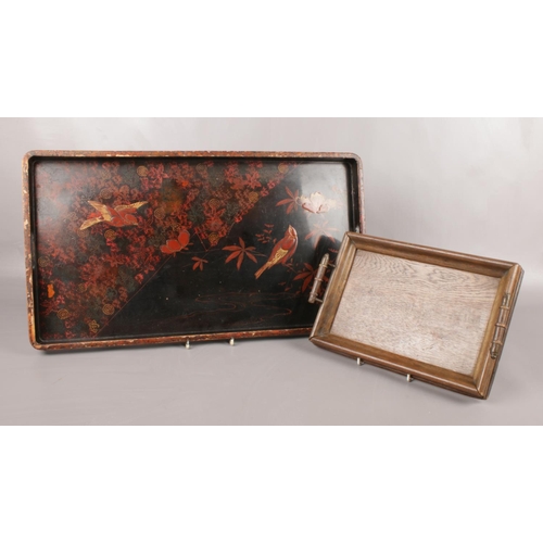 10 - Two wooden trays. Comprising of a small oak tray with handles and a larger lacquered tray in black w... 