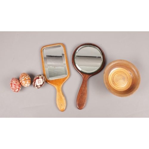56 - A small selection of wooden items. To include two wooden bevelled edged vanity mirrors, a turned woo... 
