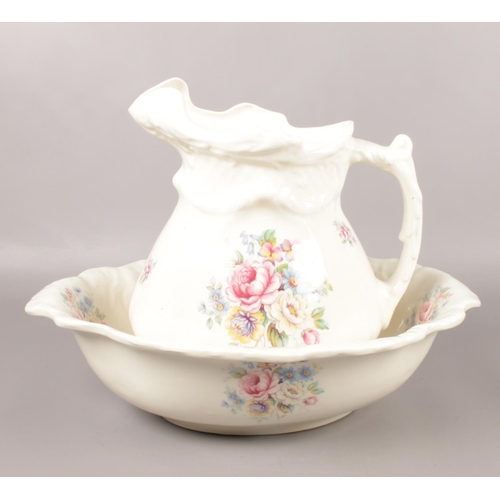 13 - A vintage ceramic jug & wash bowl, with floral pattern.