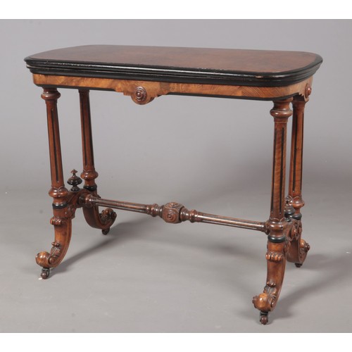 A Victorian burr-walnut veneered card table, with rectangular fold-over top and rounded corners, moulded edge & inset green baize surface. On turned supports with carved cabriole legs & centre stretcher.