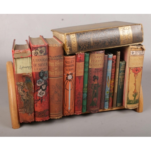 16 - A Carved Wooden Bookstand complete with Fourteen Novels, including the Pickwick Papers and a Volume ... 