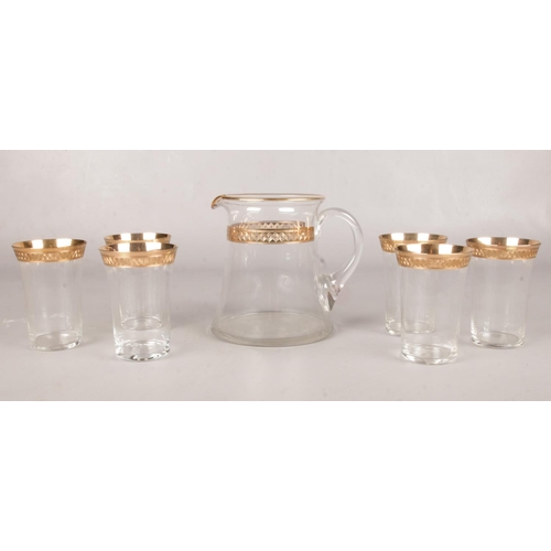 34 - A set of six gilt rimmed water glasses & water jug.