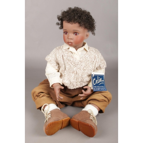 45 - A Porcelain Celia Sitting Doll, 'Taylor' 9/200, in Beige Clothing and Suede Boots.