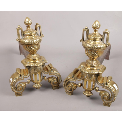 21 - A pair of urn cast iron and brass fire dogs.