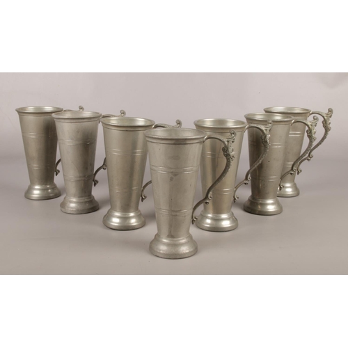 11 - A collection of vintage pewter tankards. (7) H. Bros, with handle detailing, 18cm height.