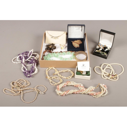 33 - A collection of costume jewellery. Includes Swarovski brooch, pearls, white paste necklet, expanding... 