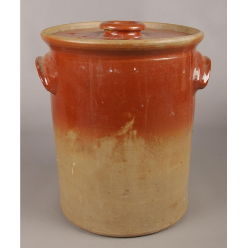 42 - A vintage stoneware crock pot. With lid and twin handles. 35cm.
