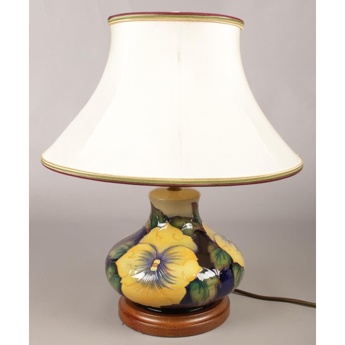51 - A Moorcroft ceramic lamp decorated with yellow flowers. Raised on oak base.