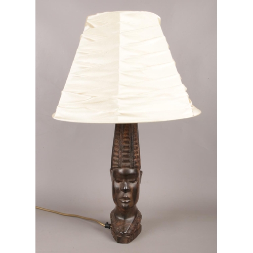 41 - A hardwood table lamp with cream shade, depicted as a Tribal figure head. In working order.