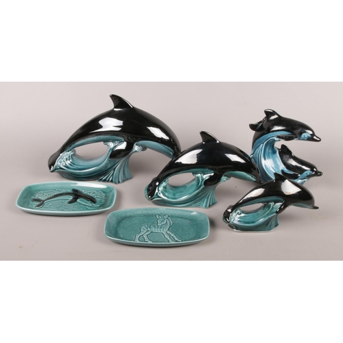 7 - Six pieces of Poole ceramics. To include a set of three graduated dolphins (largest 28cm nose to tai... 