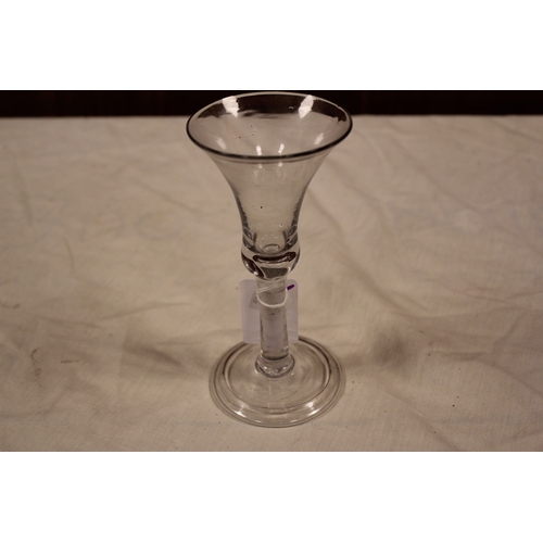298 - A Georgian tear shaped wine glass, bubble decorated and resting on a fold over base.
