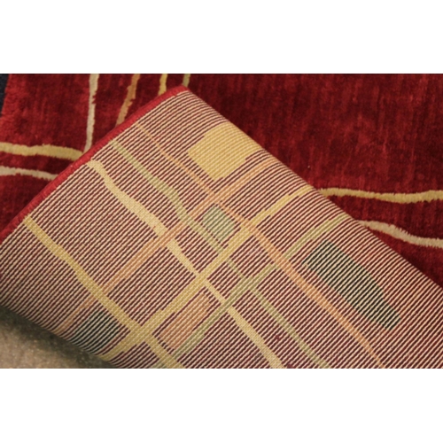 294 - A Dark Red Axminister 1950's design rug decorated with stripes and squares. Measuring:
168cms Long x... 