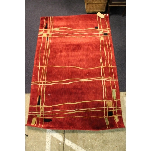 294 - A Dark Red Axminister 1950's design rug decorated with stripes and squares. Measuring:
168cms Long x... 