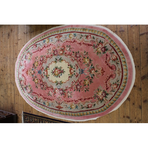 296 - A Lovely Oval Washed Chinese Rug in a Floral Pink Design. Measuring: 288cms long x 193cms Wide.