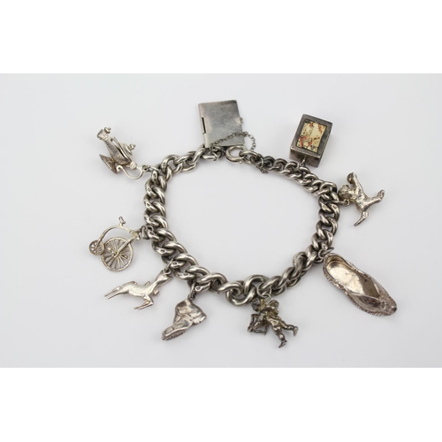 18 - A Silver Charm Bracelet including: Cupid, Lamp, Penny Farthing, etc.