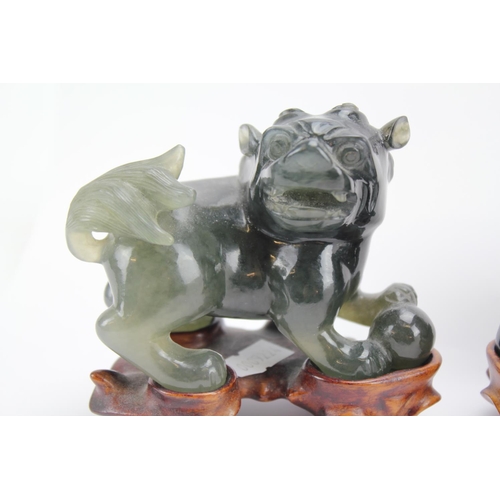 134 - A Scarce Pair of Chinese Green carved Jade male Kylin's standing on wood bases.