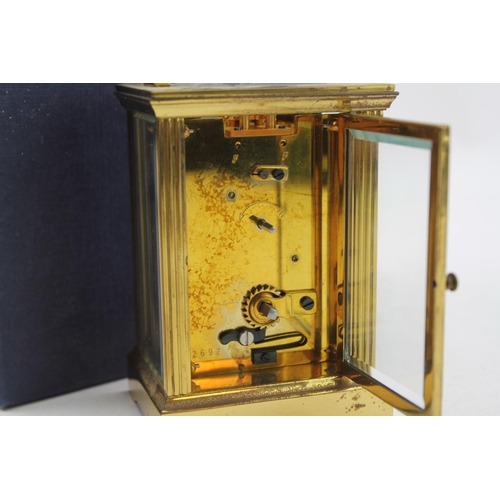 133 - A Brass cased 4 plate carriage clock, with visible escapement, swing handle, contained in a Garrard ... 