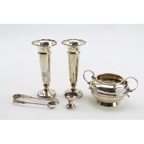 23 - A Pair of Silver spill vases, a pair of sugar tongs and a two handled sugar bowl.