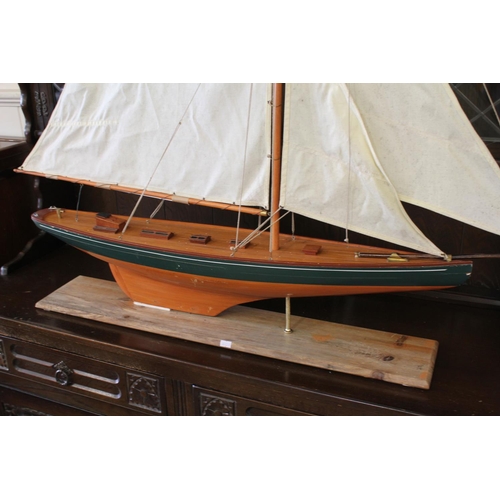 669 - A Scratch Built Model of a Single Mast Racing Boat rigged with Sales on a Wooden Plinth. Measuring: ... 