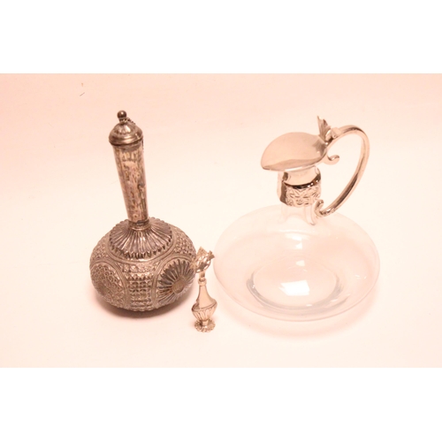 227 - An Indian embossed Silver coloured white metal sprinkler along with a scent bottle and a decanter.