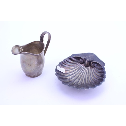 25 - A Silver Shell Shaped Butter Dish along with a Helmet Shaped Cream jug. Weighing: 132 grams.