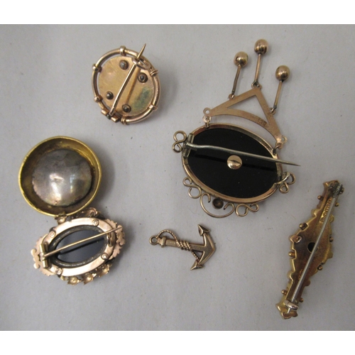 14 - Six Victorian and later gold and yellow metal mourning and other brooches: to include a 15ct gold ba... 