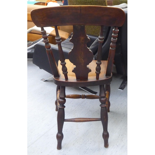 3 - A set of four late Victorian beech and elm framed Windsor chairs, each with a spindled and roundel s... 