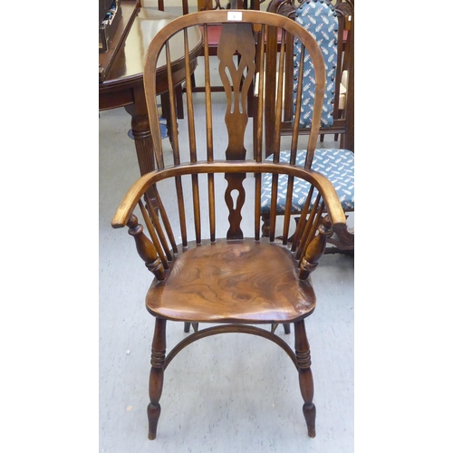 6 - A 19thC Windsor beech and elm framed high hoop, spindled and splat back arm chair, the solid seat ra... 