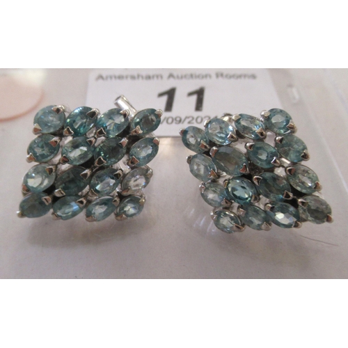 11 - A pair of silver coloured metal earrings, set with multiple blue stones  stamped 925  ... 