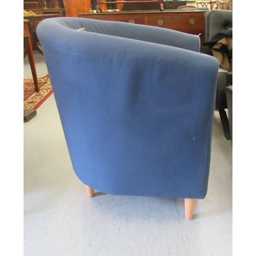 17 - A modern tub style chair, upholstered in navy blue fabric with a cushion seat, raised on turned beec... 