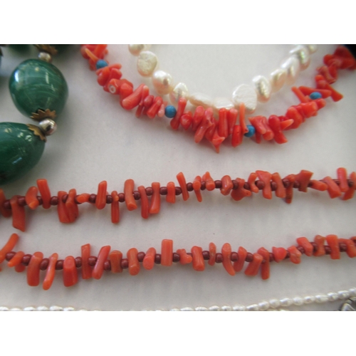21 - Costume jewellery: to include freshwater pearl necklaces and a simulated coral necklaces