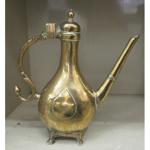 33 - A 19thC Persian engraved brass coffee pot of bulbous form with a narrow neck, hinged lid, angled spo... 