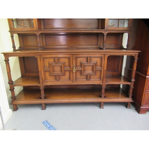 37 - An early/mid 20thC carved oak dresser, the panelled back superstructure with glazed panelled doors a... 