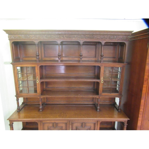 37 - An early/mid 20thC carved oak dresser, the panelled back superstructure with glazed panelled doors a... 