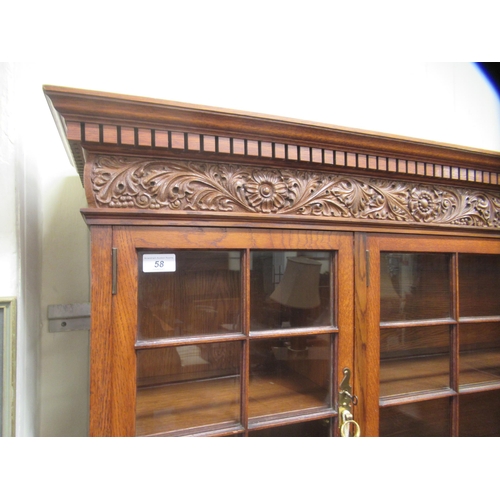58 - A mid 20thC carved oak dresser, the panelled back and pillared superstructure with four inline glaze... 